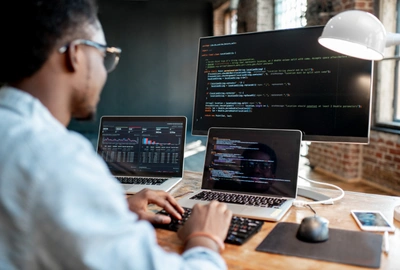 Developer writing mobile application code on a laptop